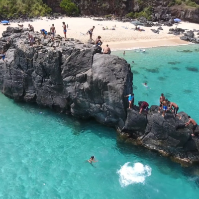 a group of people on a rock in a pool of water on a tour of oahu